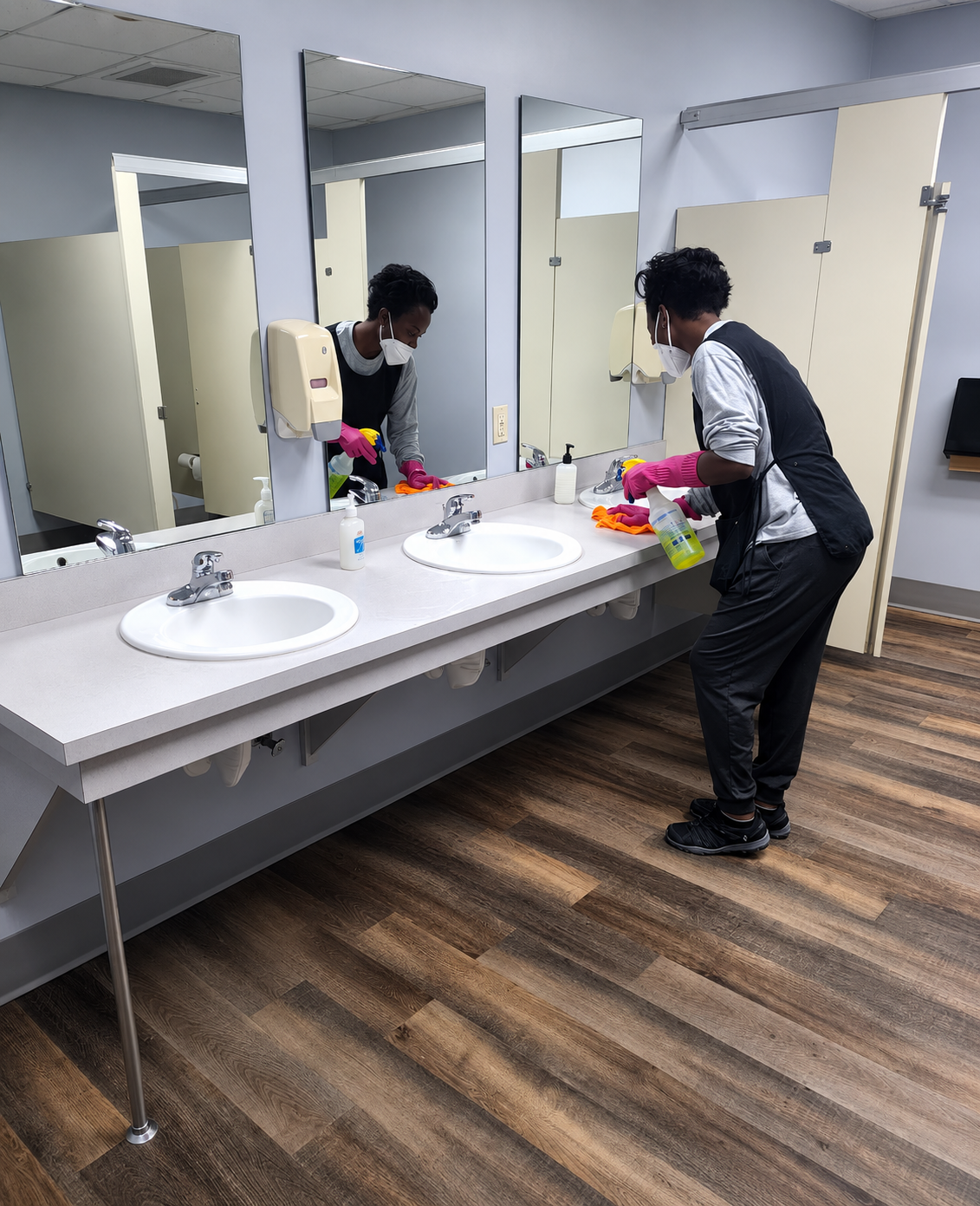 Cleaning professional wiping down a commercial restroom counter